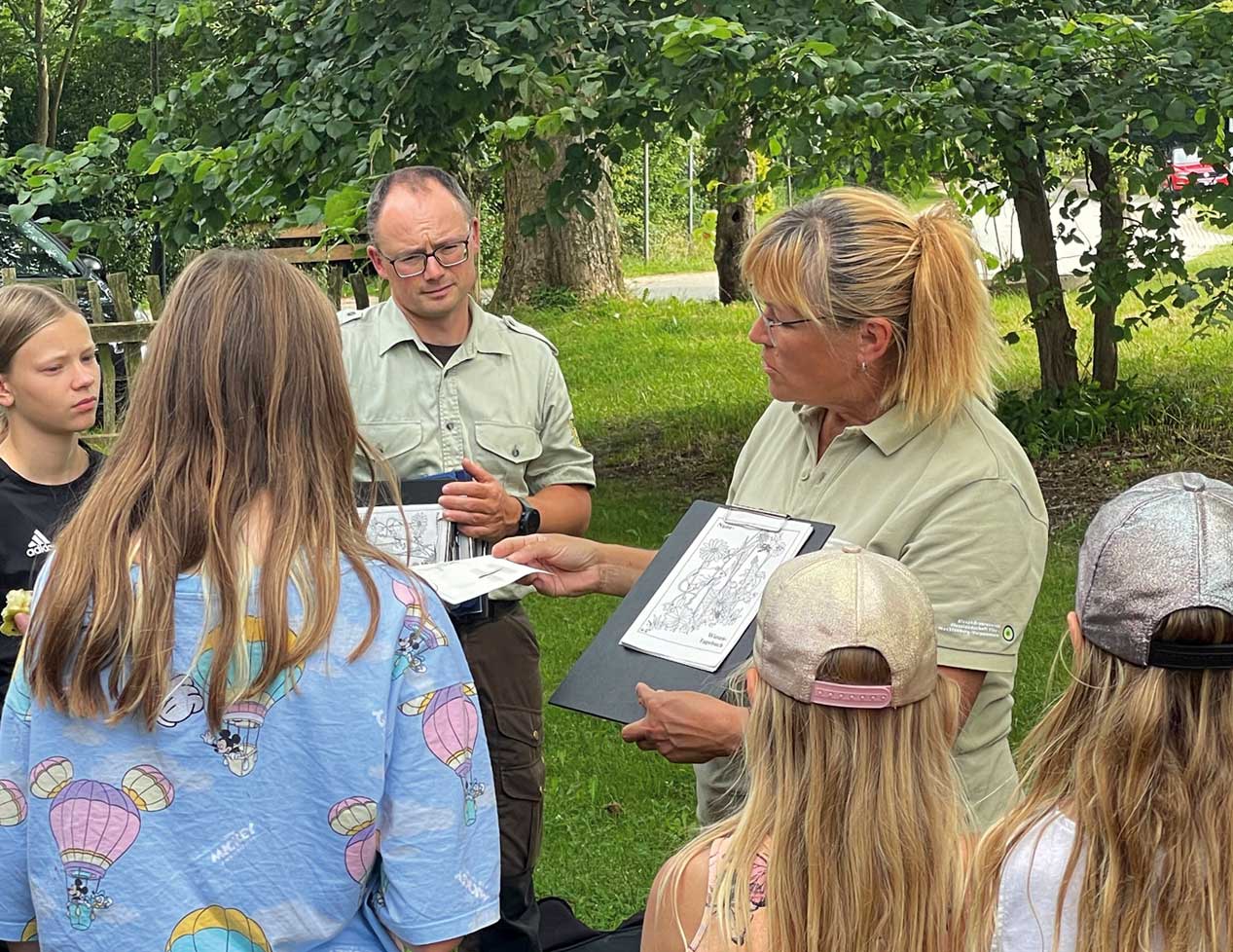 Die Ranger Kerstin Titho (rechts im Bild) und Paul Neumann vom Biosphärenreservatsamt Schaalsee-Elbe zeigen den Teilnehmenden des KinderFerienSpaß-Biosphäre die blühende Vielfalt auf Wiesen